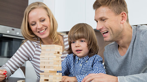 Happy parents playing blocks to their son photo